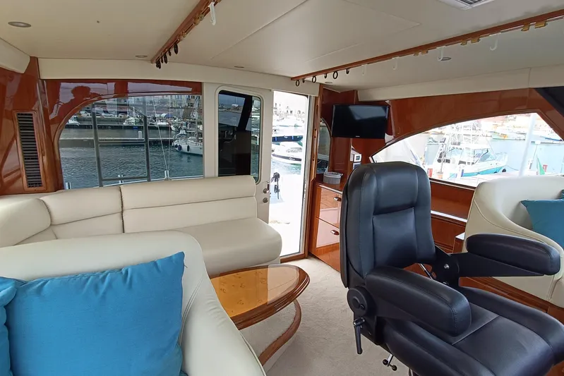 Tia Yacht Photos Pics Luxurious interior of 2017 Viking 62 Enclosed Bridge yacht with leather seating and marina view.