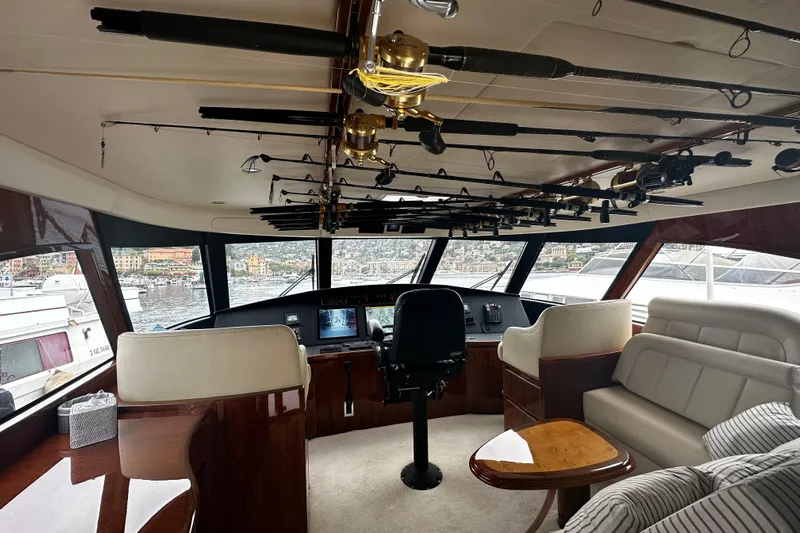 Tia Yacht Photos Pics Interior of 2017 Viking 62 Enclosed Bridge yacht with fishing rods and luxurious seating.