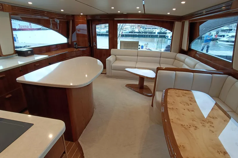 Tia Yacht Photos Pics Luxurious interior of 2017 Viking 62 Enclosed Bridge yacht with elegant seating and wood finishes.