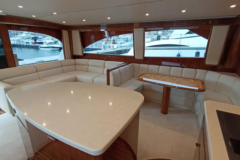 Tia Yacht Photos Pics Luxurious interior of 2017 Viking 62 Enclosed Bridge yacht with elegant seating and dining area.