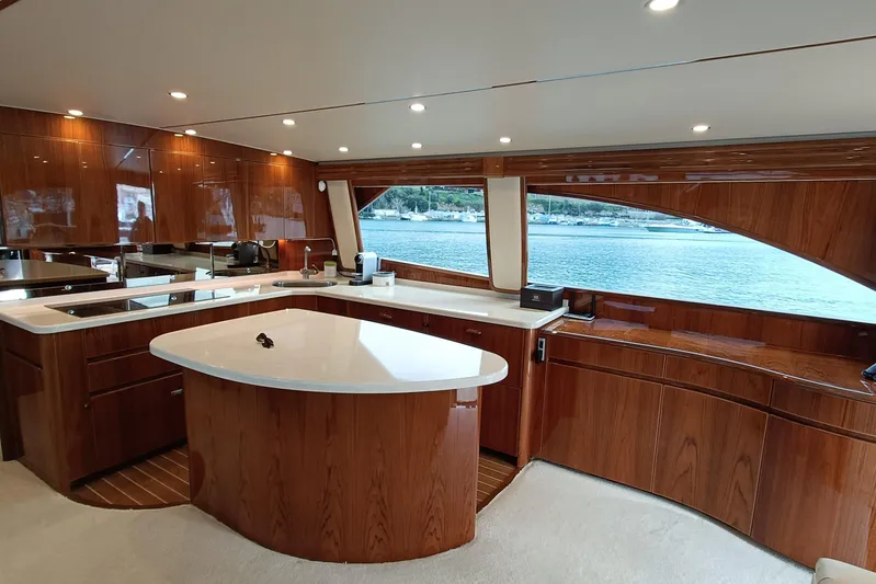 Tia Yacht Photos Pics Luxurious interior of 2017 Viking 62 Enclosed Bridge yacht with elegant wood finishes.