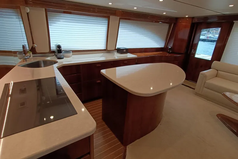 Tia Yacht Photos Pics Luxurious interior of 2017 Viking 62 Enclosed Bridge yacht with modern kitchen and seating area.
