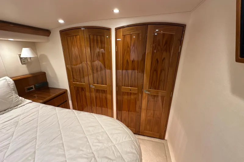 Tia Yacht Photos Pics Luxurious cabin interior of 2017 Viking 62 Enclosed Bridge yacht with wooden closets.