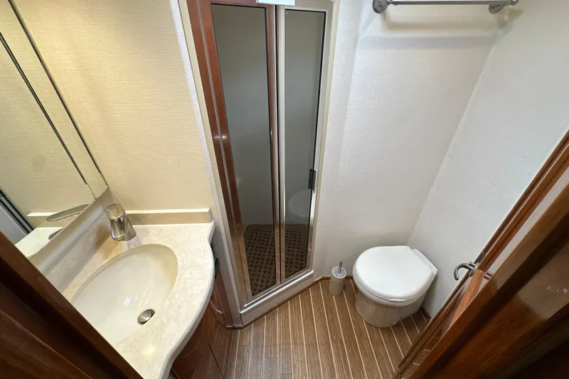 Tia Yacht Photos Pics Bathroom interior of 2017 Viking 62 Enclosed Bridge yacht with shower, sink, and toilet.