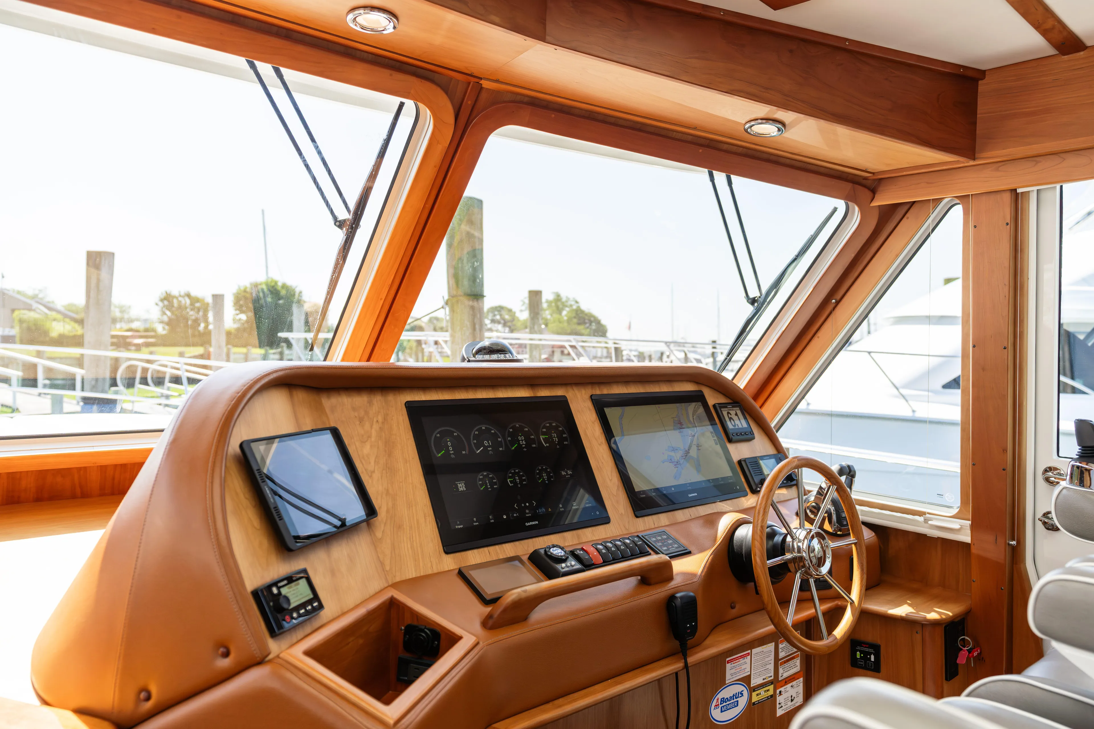 Gracious Yacht Photos Pics Helm of 2020 Sabre 48 Salon Express with modern navigation equipment and wooden finish.