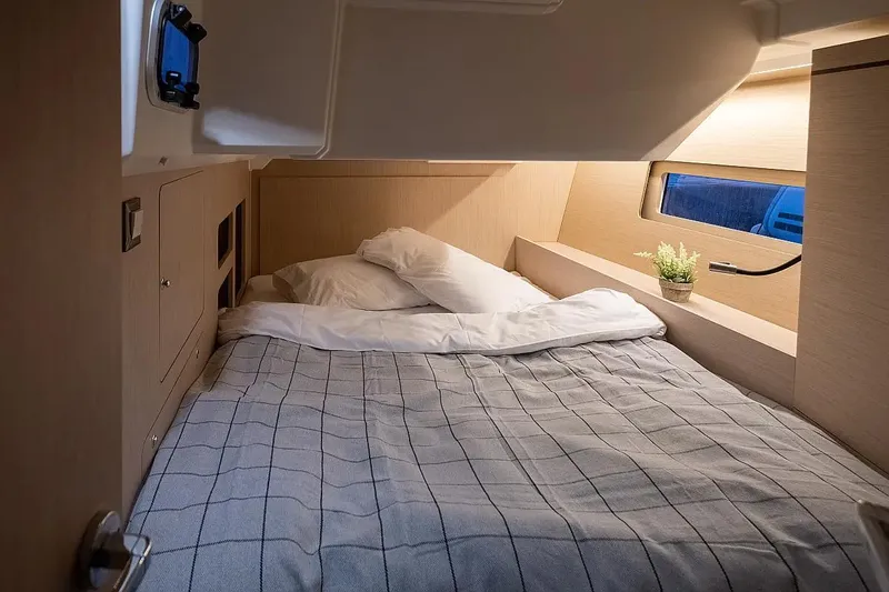  Yacht Photos Pics Cozy cabin interior of 2021 Beneteau Oceanis 46.1 yacht with bed and window view.