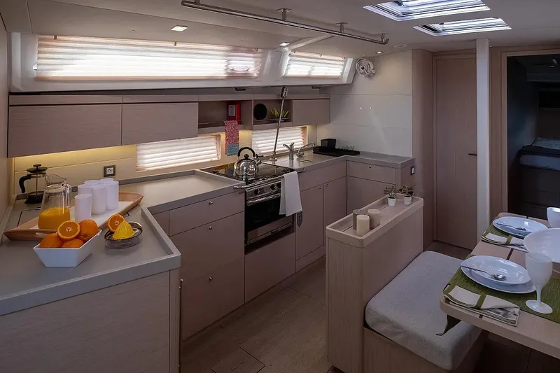  Yacht Photos Pics Modern kitchen interior of 2021 Beneteau Oceanis 46.1 yacht, featuring sleek design and dining area.