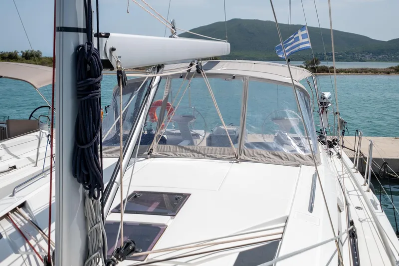  Yacht Photos Pics 2021 Beneteau Oceanis 46.1 yacht docked, featuring a Greek flag and scenic mountain backdrop.