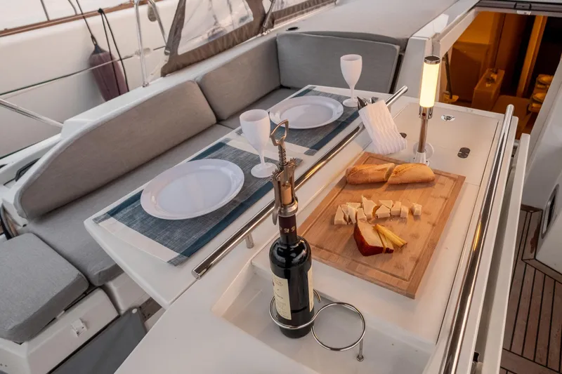  Yacht Photos Pics Luxurious dining setup on 2021 Beneteau Oceanis 46.1 yacht with wine, cheese, and bread.