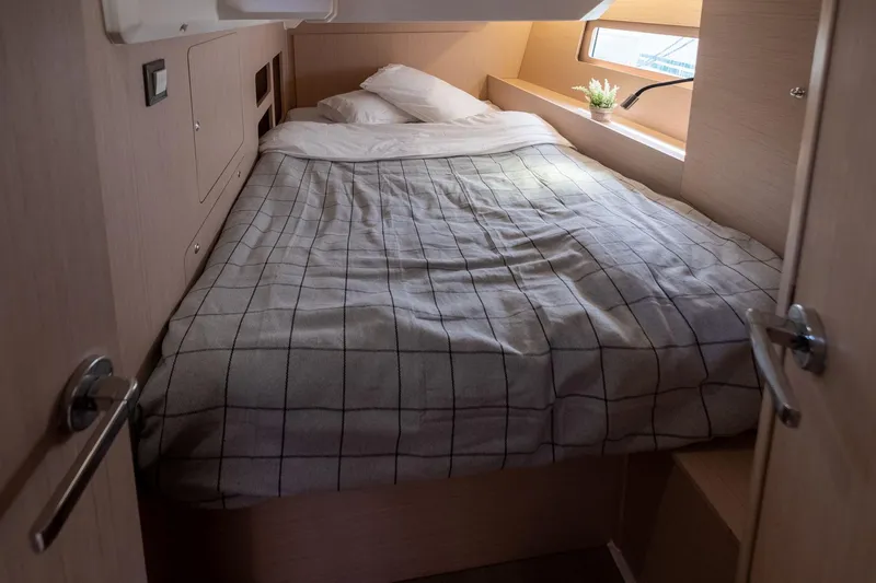  Yacht Photos Pics Cozy cabin interior of 2021 Beneteau Oceanis 46.1 yacht with bed and window.