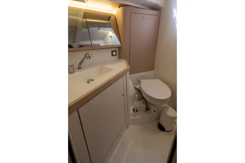  Yacht Photos Pics Modern bathroom in 2021 Beneteau Oceanis 46.1 yacht, featuring sink and toilet.