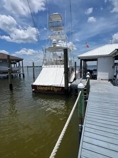  Yacht Photos Pics 2005 Cabo 40 Flybridge boat docked, named "Island Flyer," under a clear blue sky.