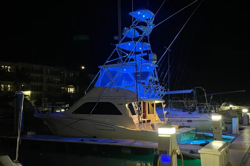  Yacht Photos Pics 2005 Cabo 40 Flybridge yacht illuminated at night in marina.