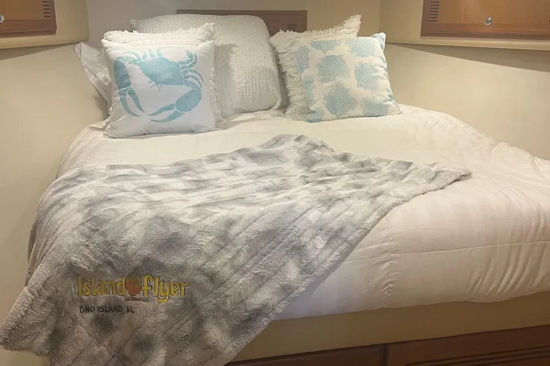  Yacht Photos Pics Cozy cabin bed in 2005 Cabo 40 Flybridge with nautical-themed pillows and soft blanket.