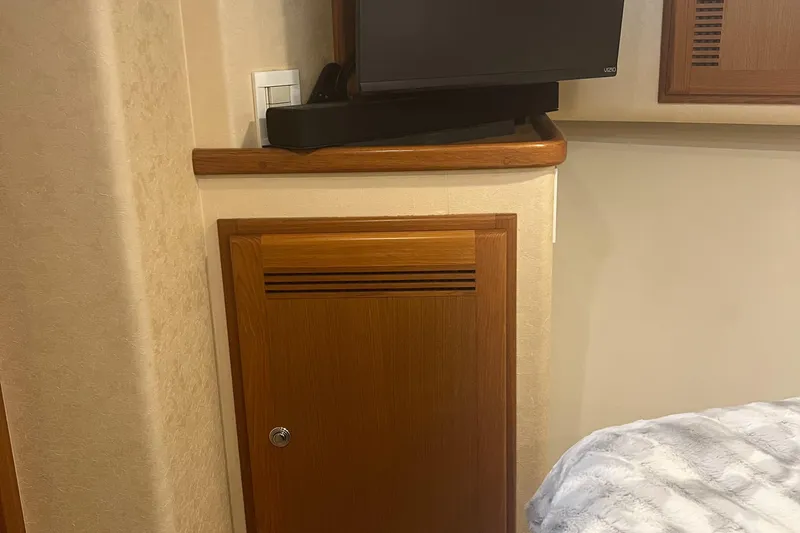  Yacht Photos Pics Interior of 2005 Cabo 40 Flybridge with wooden cabinet and mounted TV.