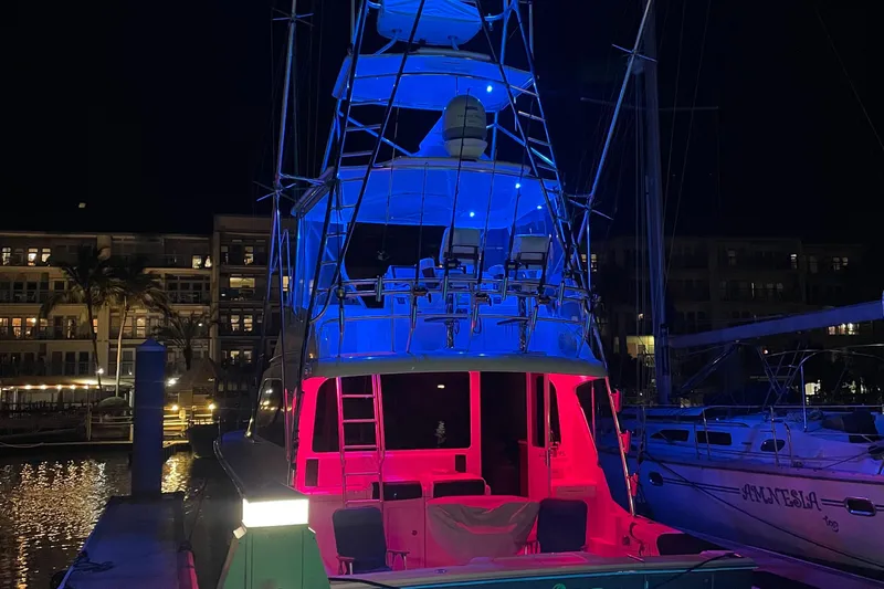  Yacht Photos Pics 2005 Cabo 40 Flybridge yacht illuminated with vibrant blue and red lights at night.