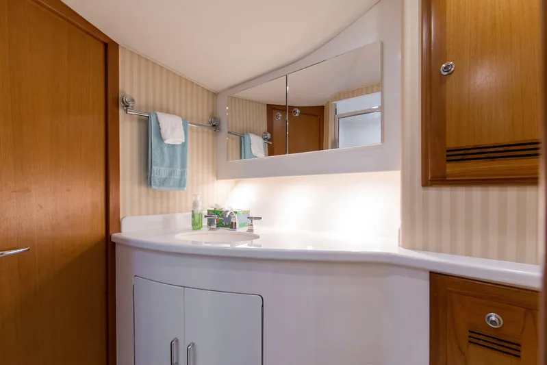  Yacht Photos Pics Luxurious bathroom interior of 2005 Cabo 40 Flybridge yacht with wooden cabinets and modern fixtures.