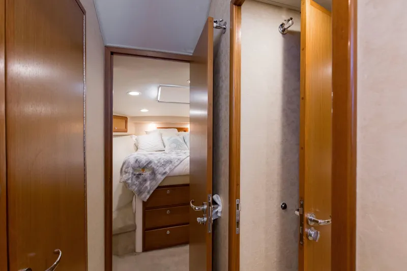  Yacht Photos Pics Interior of 2005 Cabo 40 Flybridge yacht, featuring cozy bedroom and wooden doors.
