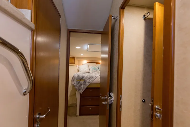  Yacht Photos Pics Interior of 2005 Cabo 40 Flybridge yacht, featuring cozy bedroom and wooden doors.
