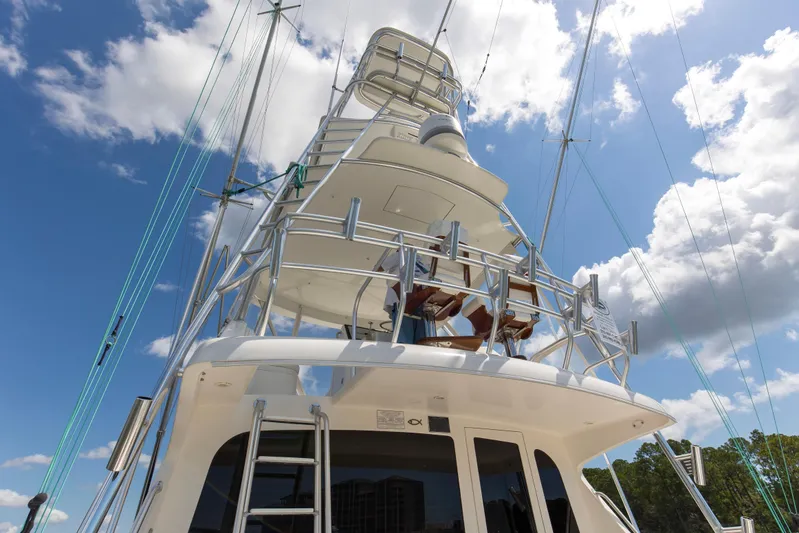  Yacht Photos Pics 2005 Cabo 40 Flybridge yacht with towering structure against a blue sky and clouds.