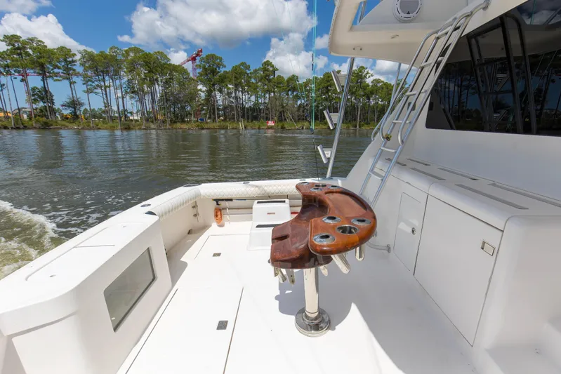  Yacht Photos Pics 2005 Cabo 40 Flybridge yacht deck with fishing station, ladder, and scenic waterway view.
