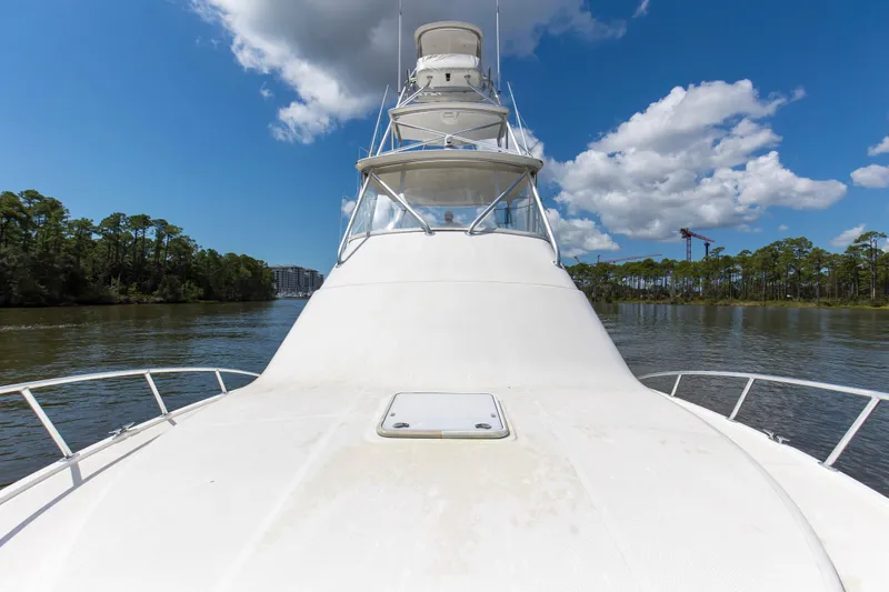  Yacht Photos Pics 2005 Cabo 40 Flybridge yacht cruising on a scenic river under a blue sky.