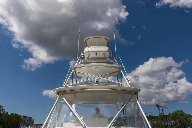  Yacht Photos Pics 2005 Cabo 40 Flybridge yacht under cloudy blue sky, showcasing its towering structure.