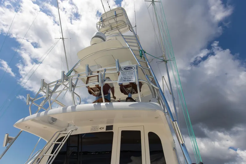  Yacht Photos Pics 2005 Cabo 40 Flybridge yacht against a cloudy sky, showcasing its sleek design and structure.