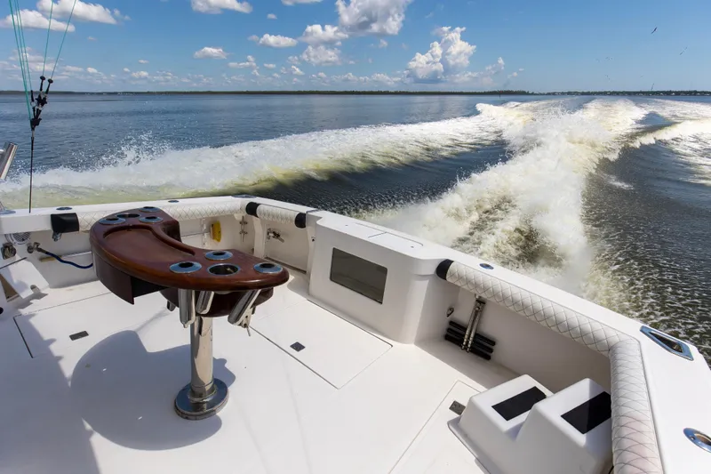  Yacht Photos Pics 2005 Cabo 40 Flybridge boat cruising on open water, featuring a spacious deck and fishing rod holders.