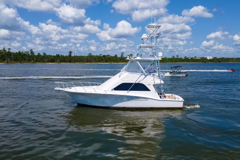  Yacht Photos Pics 2005 Cabo 40 Flybridge yacht cruising on a sunny day with blue skies.