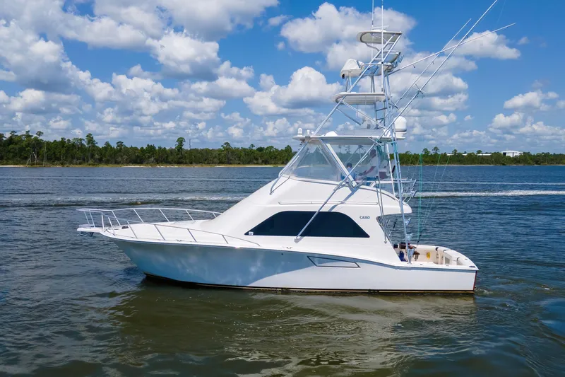  Yacht Photos Pics 2005 Cabo 40 Flybridge yacht cruising on a sunny day with blue skies.