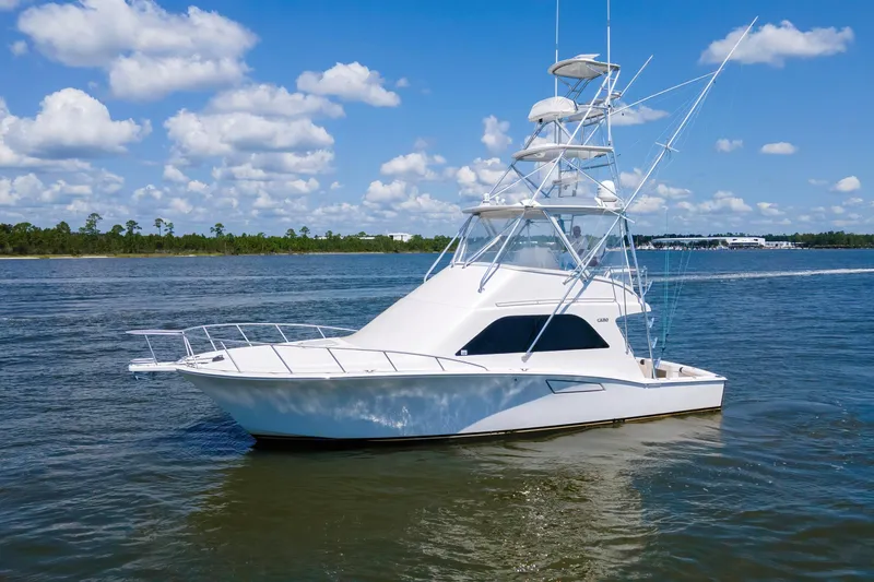  Yacht Photos Pics 2005 Cabo 40 Flybridge yacht cruising on a sunny day with blue skies.