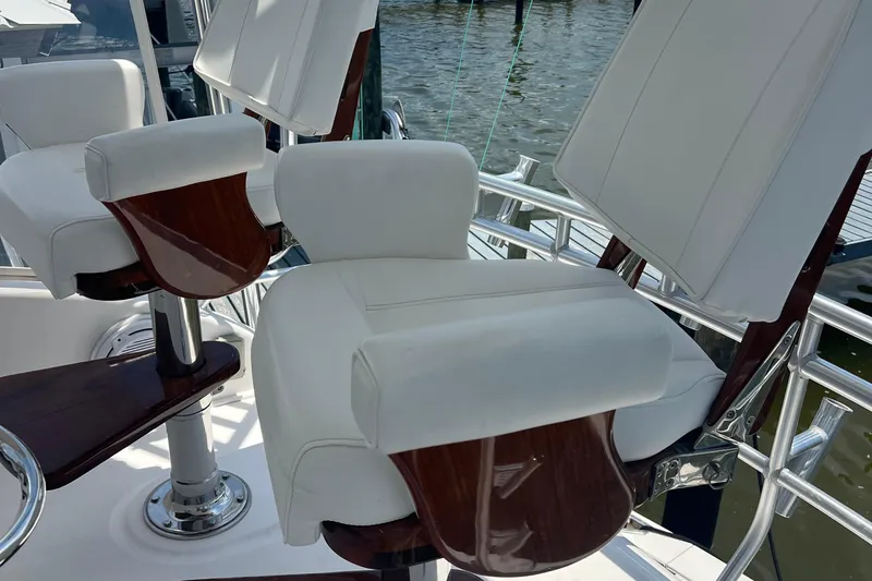  Yacht Photos Pics Luxurious seating on a 2005 Cabo 40 Flybridge yacht, featuring white cushions and wooden accents.