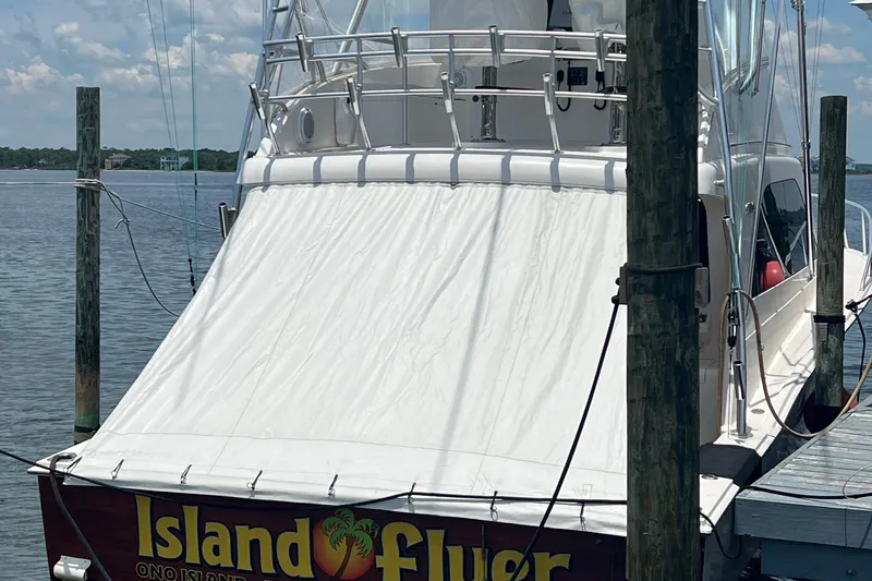  Yacht Photos Pics 2005 Cabo 40 Flybridge boat docked, featuring a white canopy and "Island Flyer" text.