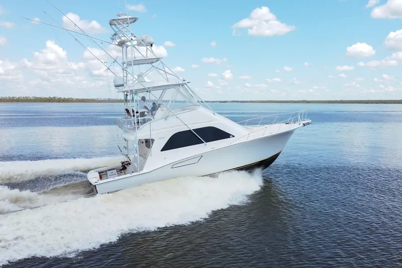  Yacht Photos Pics 2005 Cabo 40 Flybridge yacht cruising on open water under a clear blue sky.