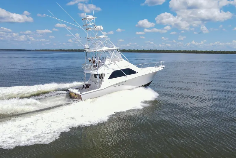  Yacht Photos Pics 2005 Cabo 40 Flybridge yacht cruising on open water under a clear blue sky.