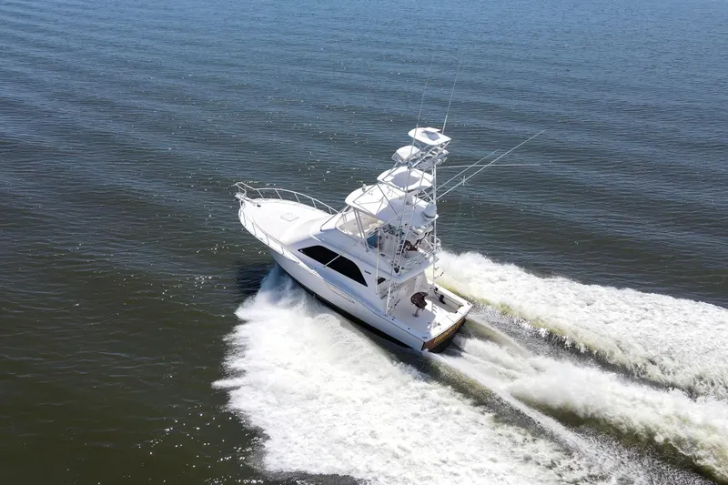  Yacht Photos Pics 2005 Cabo 40 Flybridge yacht cruising on open water, creating a wake.