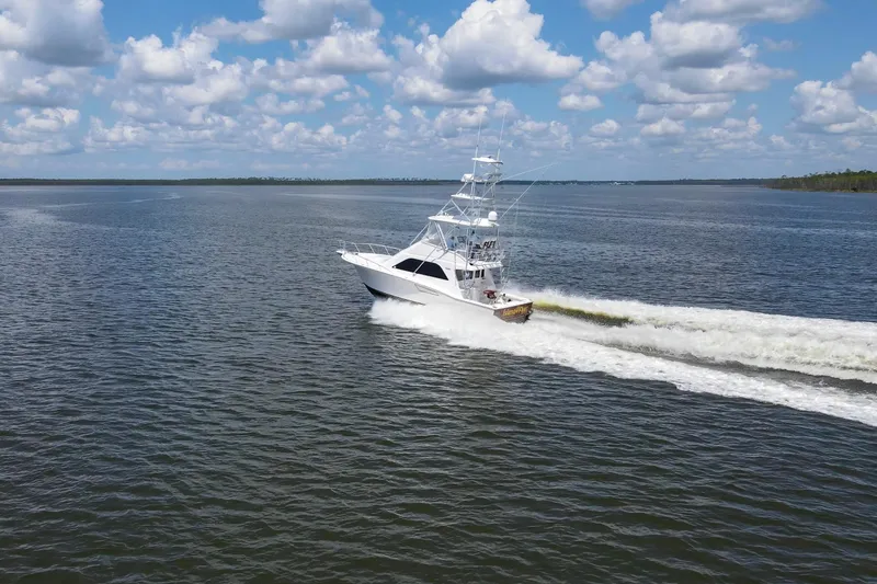  Yacht Photos Pics 2005 Cabo 40 Flybridge yacht cruising on open water under a partly cloudy sky.