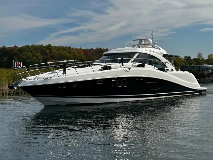 Man O War Yacht Photos Pics 2009 Sea Ray 580 Sundancer yacht on calm water under a partly cloudy sky.
