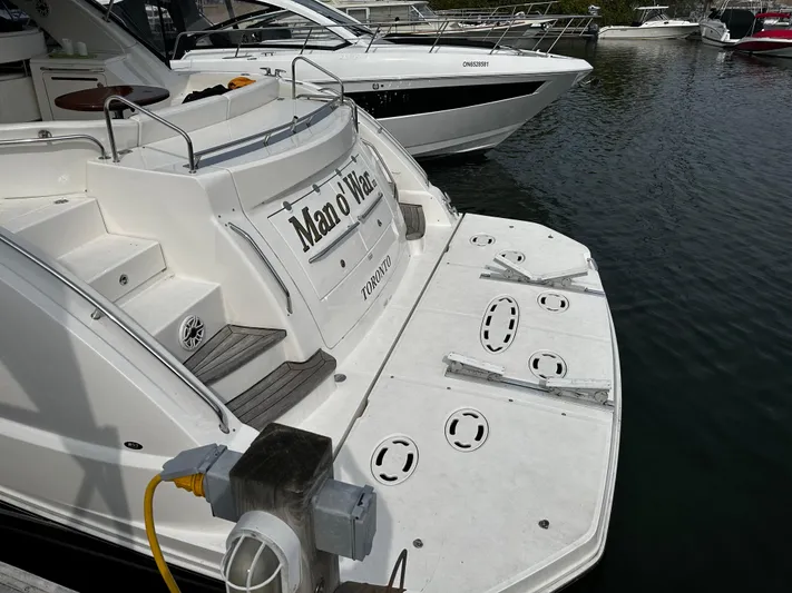 Man O War Yacht Photos Pics 2009 Sea Ray 580 Sundancer docked, rear view with swim platform and boat name visible.