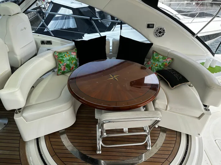 Man O War Yacht Photos Pics Luxurious seating area on 2009 Sea Ray 580 Sundancer yacht with wooden table and cushions.