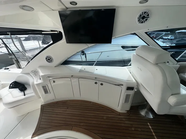 Man O War Yacht Photos Pics 2009 Sea Ray 580 Sundancer yacht interior with white seating, wood flooring, and mounted TV.