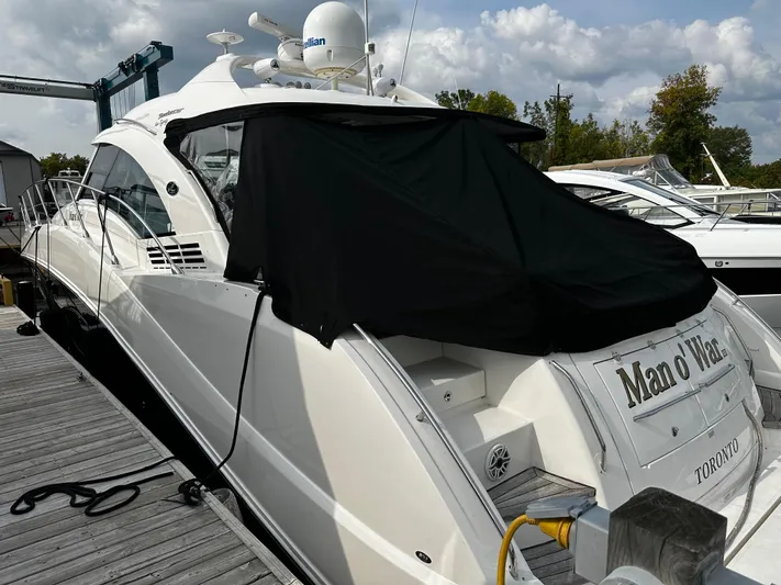 Man O War Yacht Photos Pics 2009 Sea Ray 580 Sundancer yacht docked, covered, with "Man o' War" name visible.