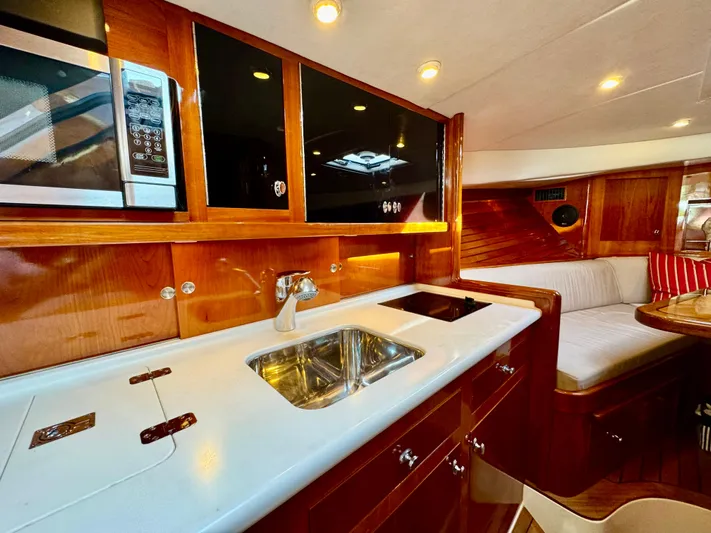 Tanacity Yacht Photos Pics Luxurious interior of 2009 Hinckley Runabout 38 with modern kitchen and seating area.