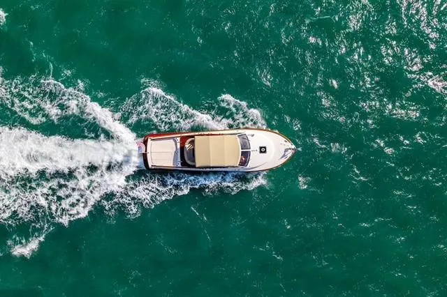 Tanacity Yacht Photos Pics Aerial view of 2009 Hinckley Runabout 38 cruising on turquoise water.