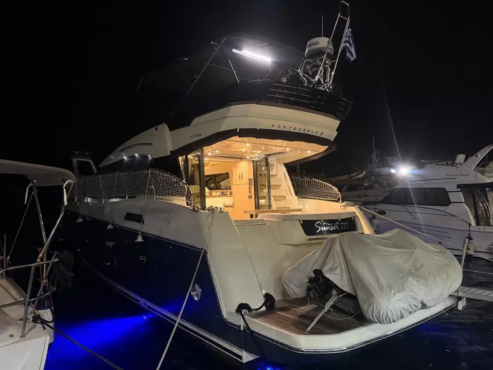  Yacht Photos Pics 2018 Beneteau Monte Carlo 5 yacht docked at night with illuminated deck.