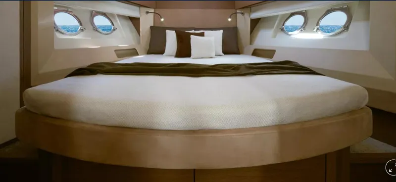  Yacht Photos Pics Luxurious bedroom interior of 2018 Beneteau Monte Carlo 5 yacht with round bed and porthole windows.