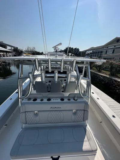Knot Free Yacht Photos Pics 2021 SeaHunter 46 CTS boat with sleek seating and rod holders, docked by waterfront homes.