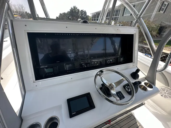 Knot Free Yacht Photos Pics Control panel of 2021 SeaHunter 46 CTS boat with steering wheel and navigation screens.