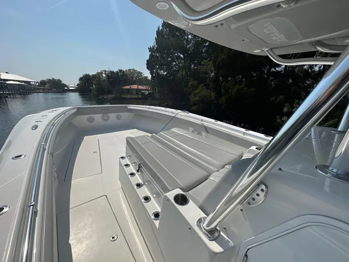 Knot Free Yacht Photos Pics 2021 SeaHunter 46 CTS boat deck with seating, docked by a scenic waterfront.